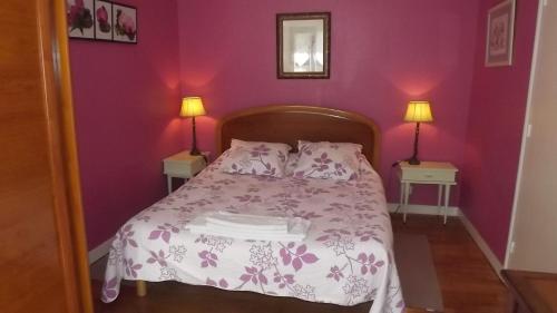 une chambre avec un lit aux murs violets et deux lampes dans l'établissement Vent de Terre, à Audierne