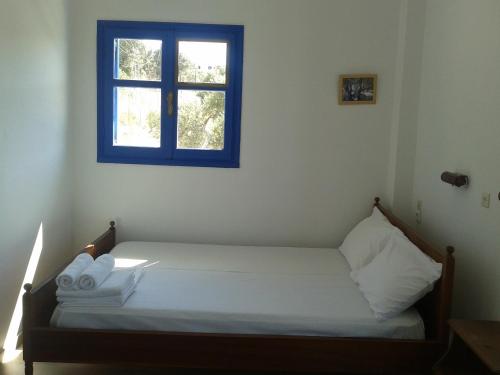 a small bedroom with a bed with a window at PanoramaKamil in Kamilari