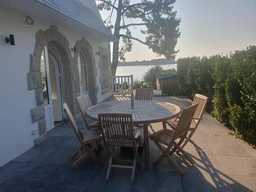 une table et des chaises en bois sur une terrasse dans l'établissement Mazi Bihan, à Combrit
