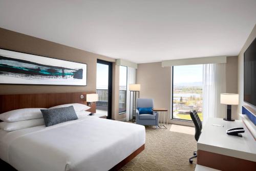 a hotel room with a bed and a desk and a computer at Delta Hotels by Marriott Thunder Bay in Thunder Bay