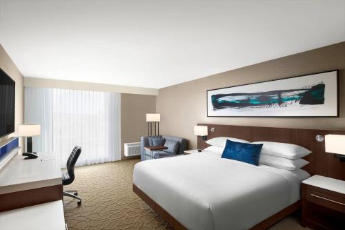 a hotel room with a large white bed and a desk at Delta Hotels by Marriott Thunder Bay in Thunder Bay