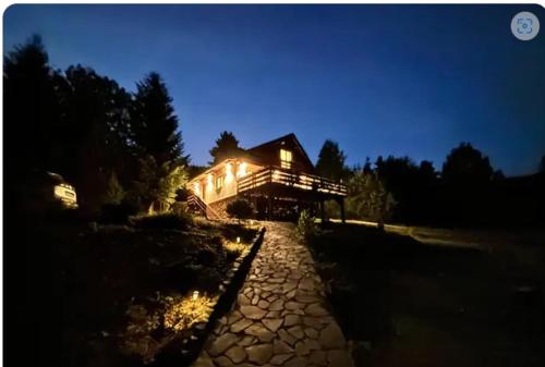 a house lit up at night with its lights on at Chata pod Grúňom in Veľké Borové