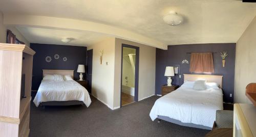 a hotel room with two beds and two lamps at Rustic Lodge in Glasgow