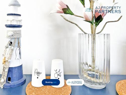 a blue table with a vase with a flower in it at Premium Deal l Hill View Home l Last-Minute Offer l Cheltenham l AJ Properties l Perfect for Short or Long Stays l 4Beds 4Bedrooms in Cheltenham