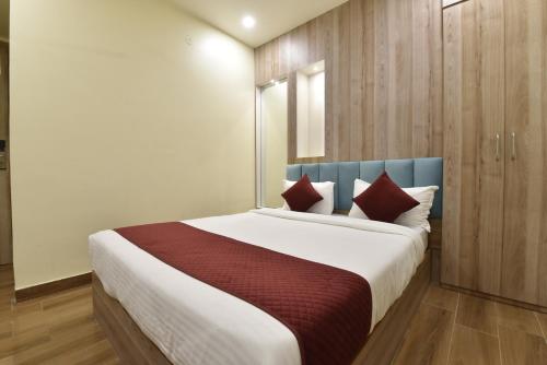 a bedroom with a large bed with red pillows at Hotel Anju Shree Inn-Near Jaipur Airport Terminal 1 in Jaipur