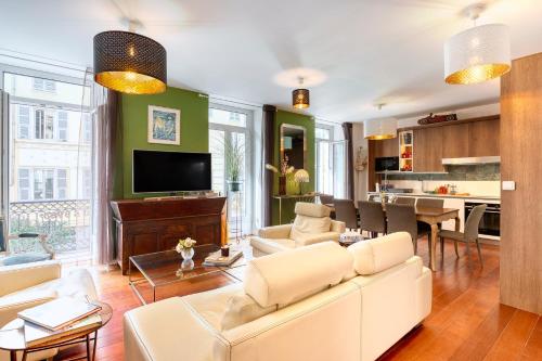 un salon avec un canapé blanc et une télévision dans l'établissement New vieille ville cimiez Centre Nice, à Nice