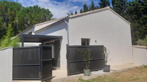 a white house with a black gate and a plant at Mas Sansonnets in Mouriès