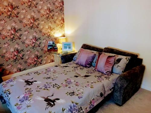 a bedroom with a bed with flowers on it at Alnwick Town Centre Apartment in Alnwick