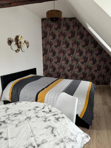 a bedroom with two beds and a chair in it at Studio 3ème étage - Centre-ville - Local vélos disponible in Mayenne