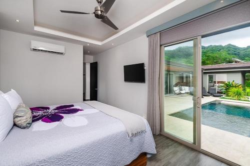 een slaapkamer met een bed en een zwembad bij Contemporary Villa 3 BD 3BA Pool in Playa Flamingo