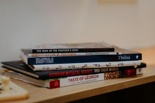 a stack of books sitting on a table at Pool House in Tbilisi City