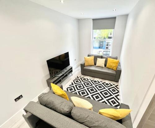 a living room with a couch and a fireplace at WOW Abbey Road Apartment - Sleeps up to 8 in London
