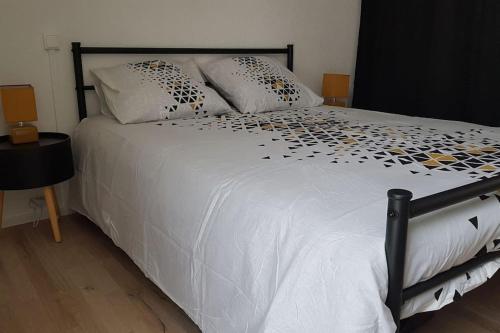 Elle comprend un grand lit blanc avec des oreillers. dans l'établissement Egat font-romeu Appartement 2ème étage, à Égat