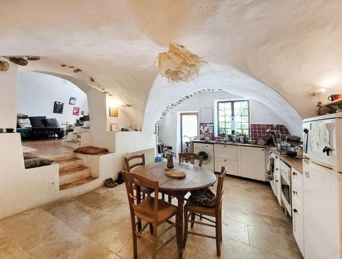 une cuisine avec une table et des chaises dans une pièce dans l'établissement Les voûtes du vieux village, à Lauris