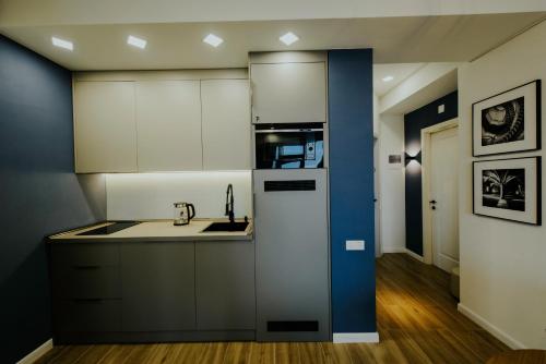 a kitchen with white cabinets and a sink at Pool House in Tbilisi City