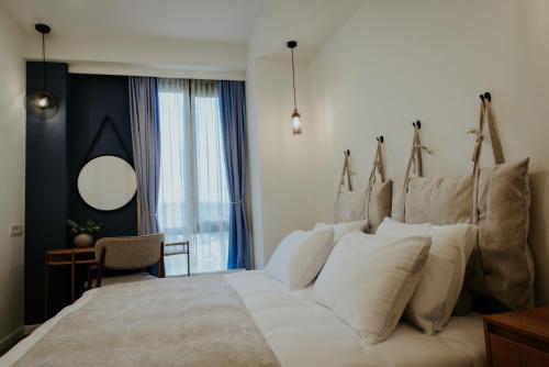 a bedroom with a large bed with white pillows at Pool House in Tbilisi City