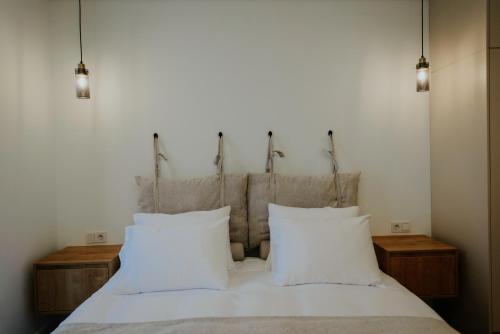 a bedroom with a bed with white sheets and pillows at Pool House in Tbilisi City
