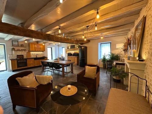 un grand salon avec une table et des chaises dans l'établissement Belle An Pierre chambre d hôte & spa 