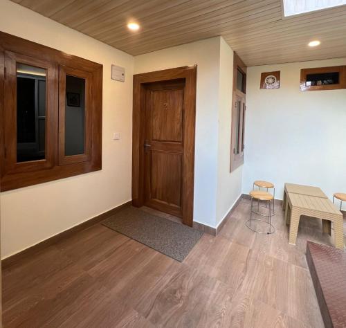 a room with a door and a table and chairs at Dolia Pahadi Stays & Cafe' in Rānīkhet