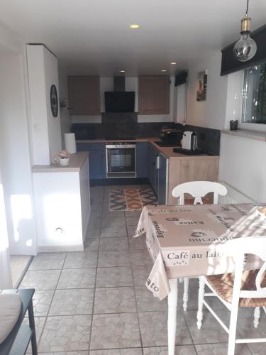 une cuisine avec une table et des chaises dans une pièce dans l'établissement Les Hortensias, à Andolsheim