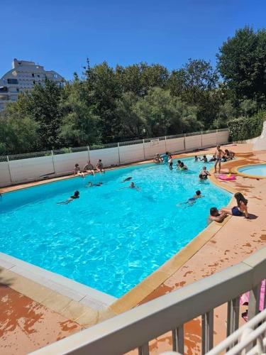 un groupe de personnes nageant dans une piscine dans l'établissement Studio cabine au couchant, à La Grande Motte