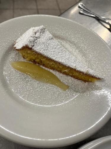 a piece of cake on a plate with powdered sugar at Hotel la Maggioressa in Ischia