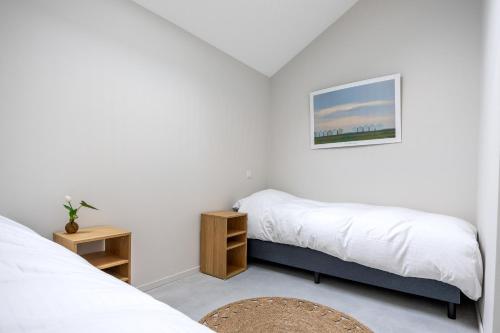 two beds in a room with white walls at Appartementen aan het water in Heeg
