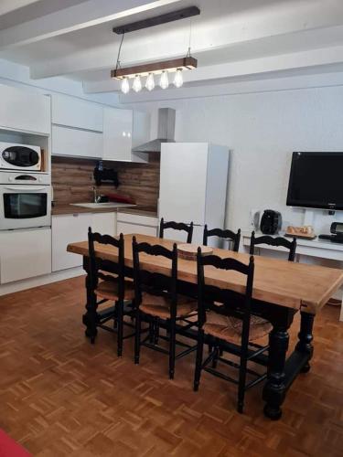 une cuisine avec une table en bois et quatre chaises dans l'établissement Praloup 1600 ideal famille, à Uvernet