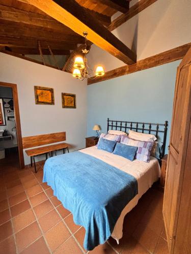 a bedroom with a bed with a blue blanket at Casa Rural Los Regajales in Tenzuela
