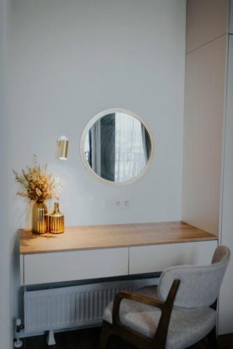 a mirror on a wall next to a chair at Pool House in Tbilisi City