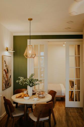 a dining room with a table and chairs and a bed at Pool House in Tbilisi City