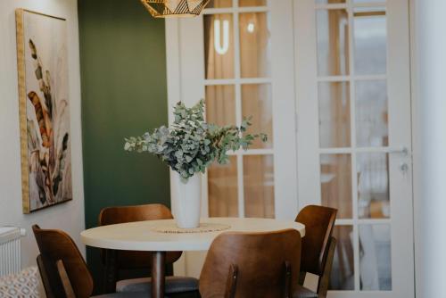 a dining room table with a vase of flowers on it at Pool House in Tbilisi City