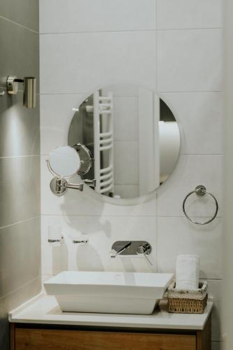 a white bathroom with a sink and a mirror at Pool House in Tbilisi City