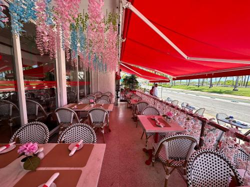 a restaurant with tables and chairs and a red canopy at Ocean Drive Steps to Sea in South Beach with Free Parking in Miami Beach
