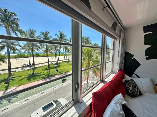 a room with a view of the beach and palm trees at Beachfront Ocean View Apartment on Ocean Drive in Miami Beach