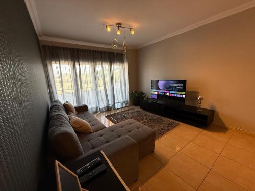 a living room with a couch and a flat screen tv at Casa de Férias Lucena in Lourinhã