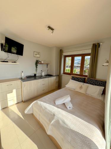 a bedroom with a large bed and a kitchen at Willa Chrycówka - Jacuzzi, Basen, Sauna in Kościelisko