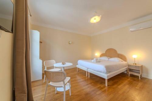 une chambre avec un lit, une table et des chaises dans l'établissement La Suite Victor Hugo, à Paris