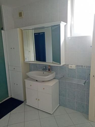 une salle de bain avec un lavabo et un miroir dans l'établissement Maison de la tuilerie, à Ambrault