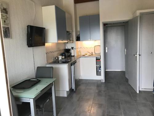 Elle comprend une petite cuisine avec une table et un bureau. dans l'établissement Studio cabine avec vue mer - 3 personnes, au Cap d'Agde