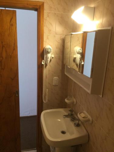 a bathroom with a sink and a mirror at Hostería Santa Bárbara in Villa Gesell