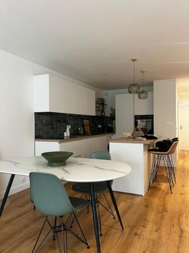 une cuisine avec une table et des chaises dans une pièce dans l'établissement Appartement Baulois neuf et central, à La Baule