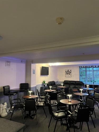 a dining room with tables and chairs and a tv at Burlington Hotel in Sandown