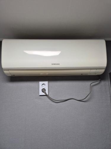 a white computer monitor with a cord plugged into it at Gangnam Seven Hostel in Seoul