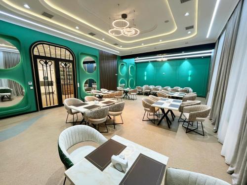a restaurant with green walls and tables and chairs at Nafta Sanatorium in Naftalan