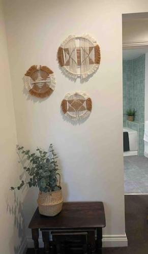 three plates on a wall with a potted plant on a table at Large town centre apartment with parking in Wallingford