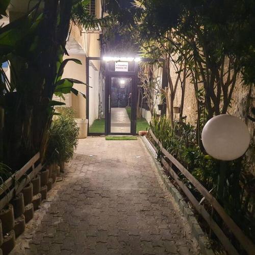 an alley way with a building with a light at night at Ryo 18 דירה במלון בוטיק 2 דקות מטיילת בת ים in Bat Yam