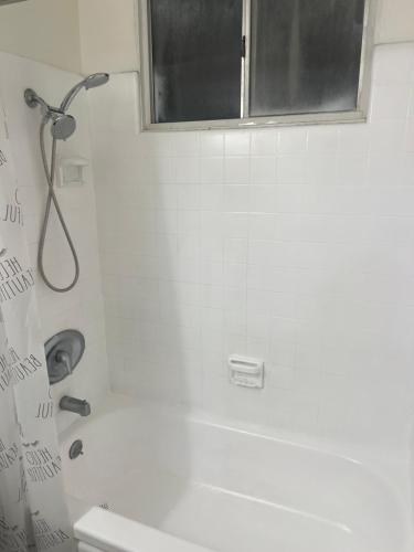 a white bathroom with a shower and a window at Inglewood Villa in Los Angeles