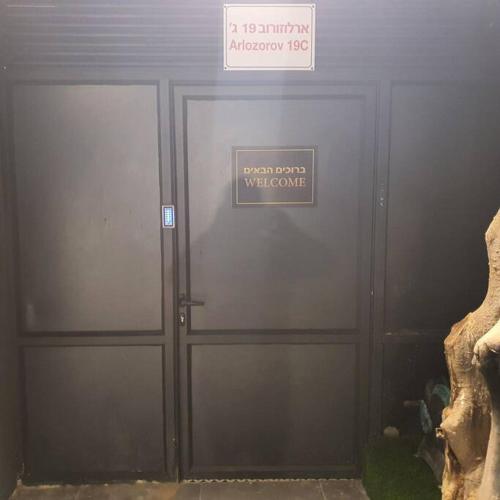 a pair of doors in a building with a sign on it at Ryo 18 דירה במלון בוטיק 2 דקות מטיילת בת ים in Bat Yam