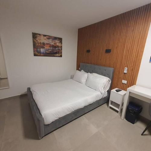 a bedroom with a bed and a desk in it at Ryo 18 דירה במלון בוטיק 2 דקות מטיילת בת ים in Bat Yam